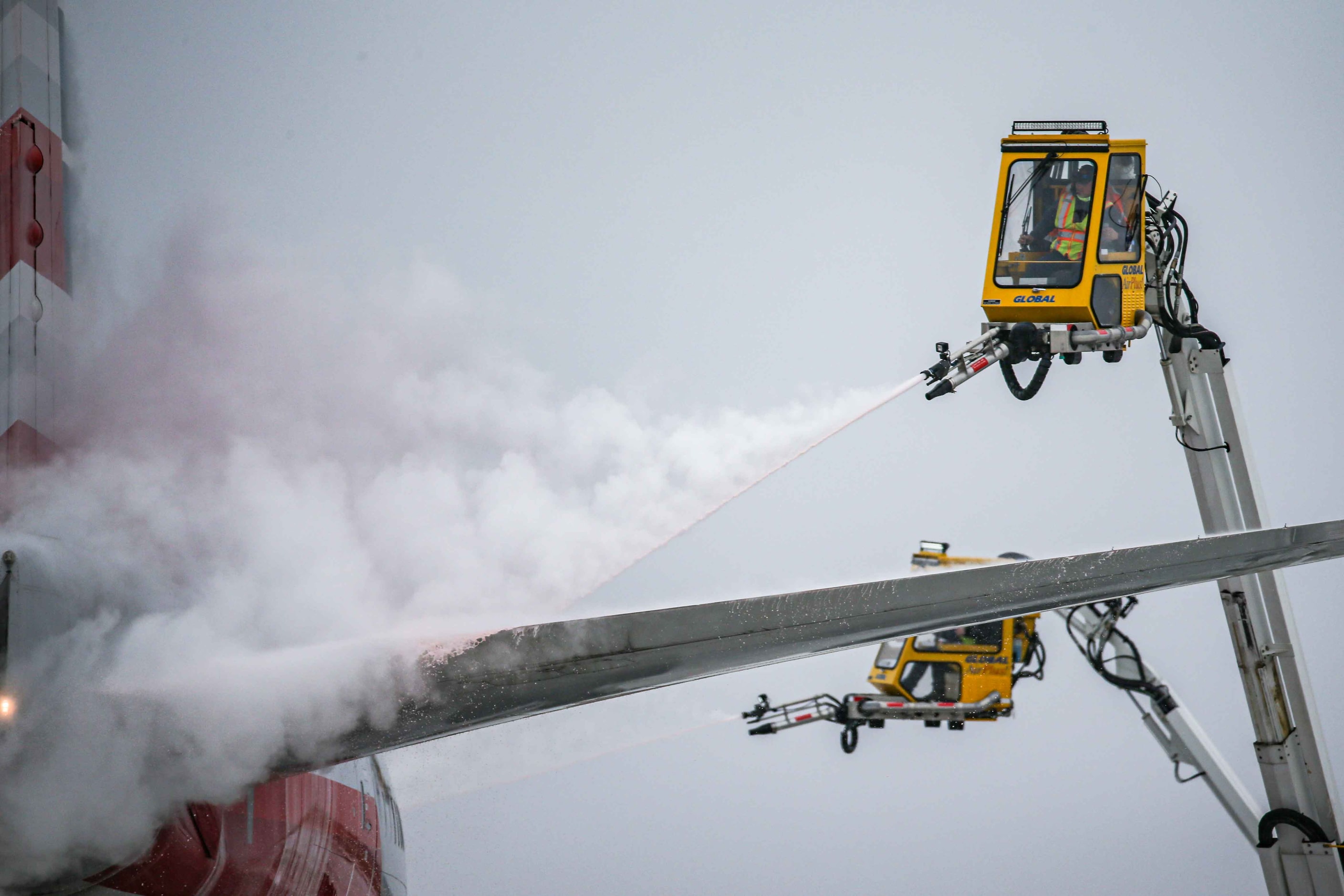 An American Airlines jet is de-iced at DFW International Airport before takeoff as winter...