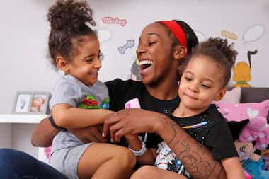 Dallas Wings' player Glory Johnson plays with her twin daughters Solei, left, and Ava in...