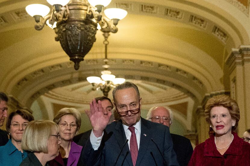 Sen. Chuck Schumer, D-N.Y., center, accompanied by the Senate Democrats, speaks to reporters...