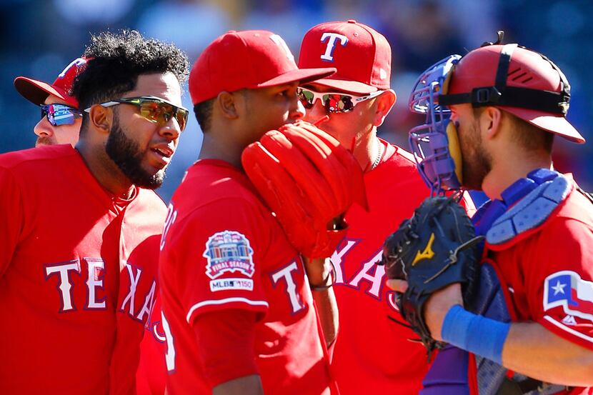 Texas Rangers relief pitcher Jose Leclerc (25) receives an earful from shortstop Elvis...