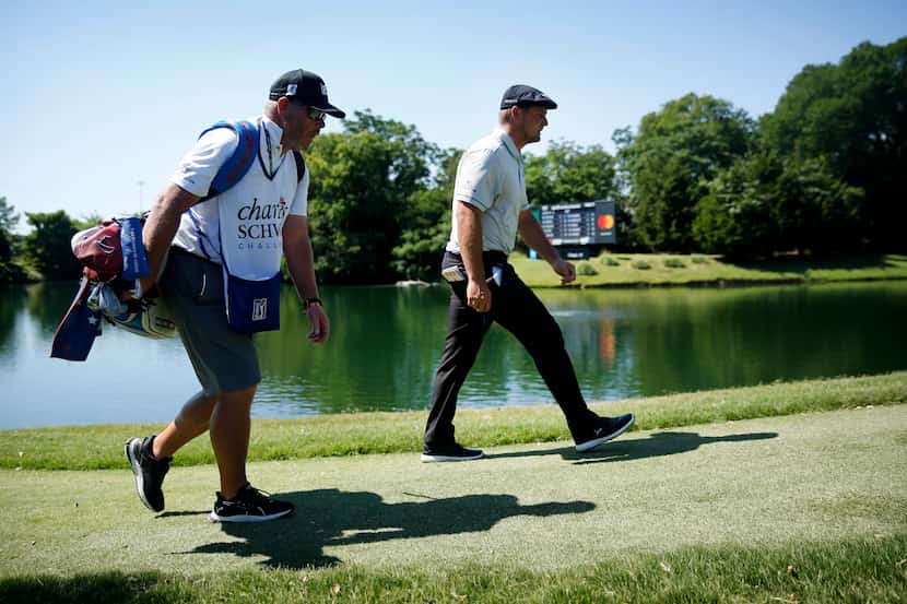 PGA Tour golfer Bryson DeChambeau and his caddie Tim Tucker walk back up the par-3, No. 13...