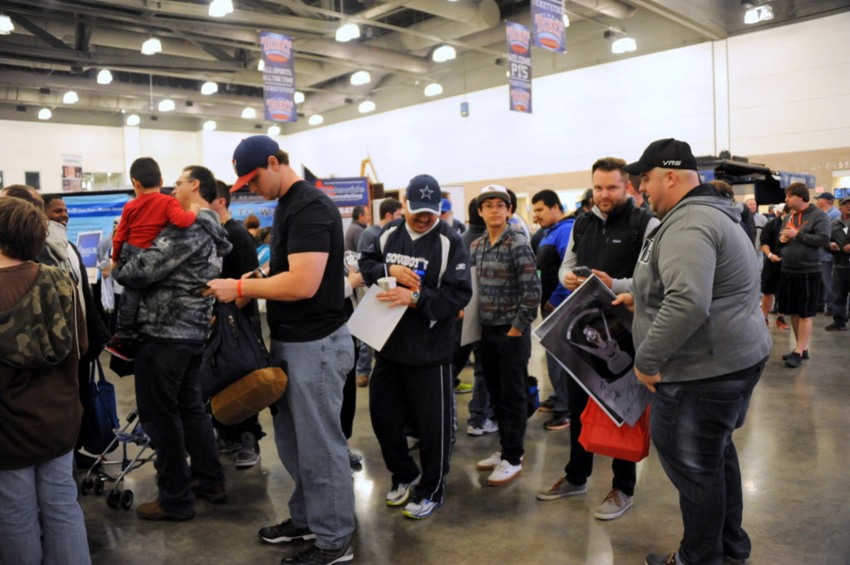 Fans wait in line to have sports memorabilia autographed by Cowboys players at The Ticket...