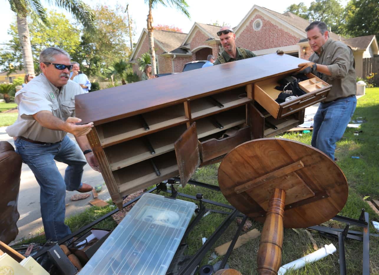 Sen. Ted Cruz (right) helps move furniture to the curb with state Sen. Larry Taylor as they...