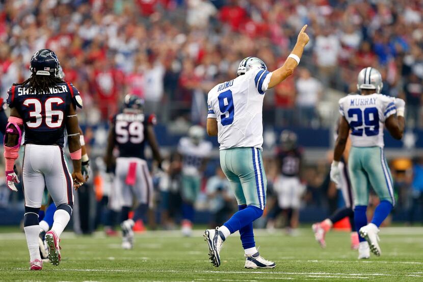 Dallas Cowboys quarterback Tony Romo (9) reacts to wide receiver Dez Bryant's (88) big catch...