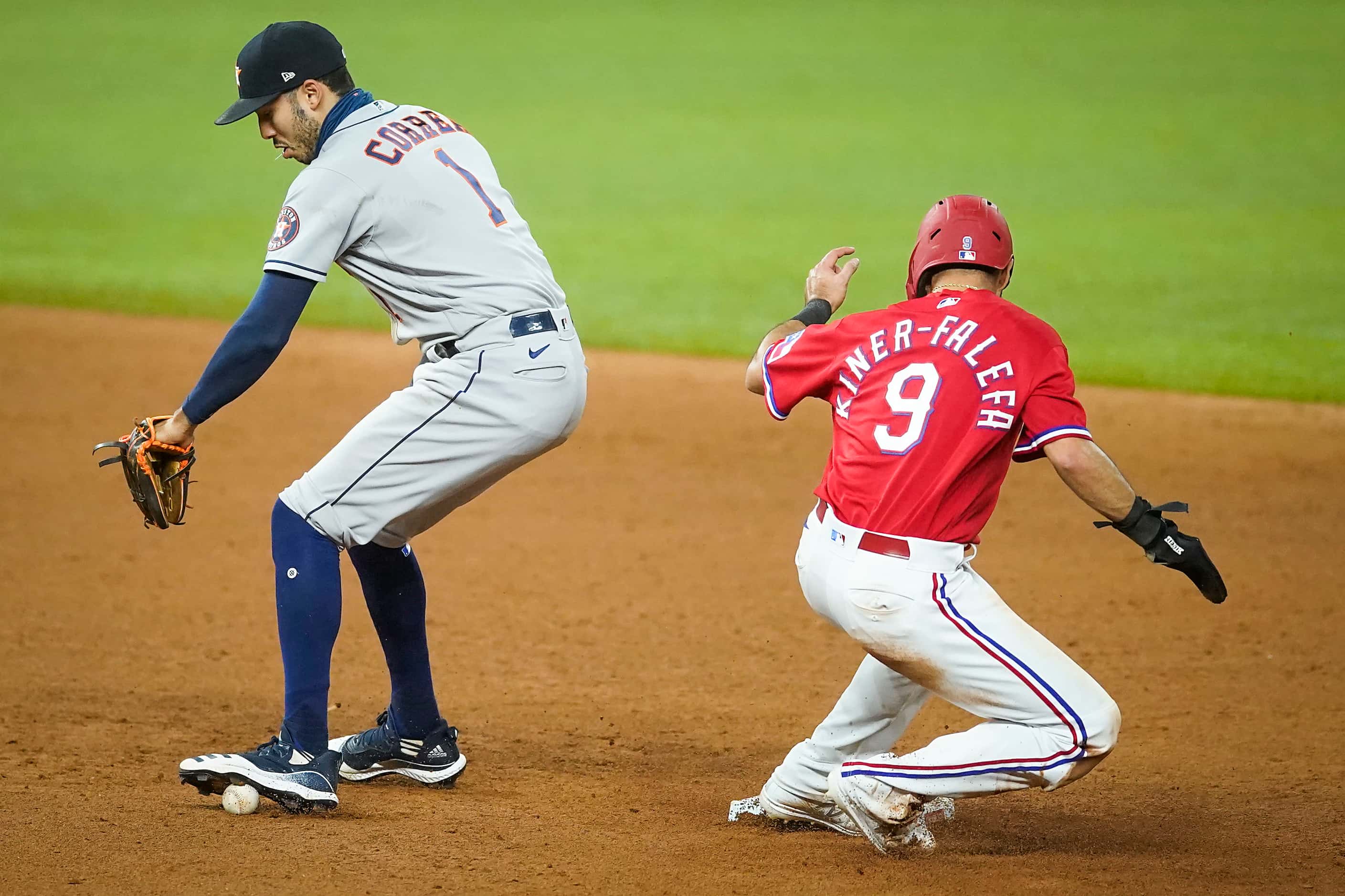 Texas Rangers shortstop Isiah Kiner-Falefa is safe at second base as the ball gets away from...