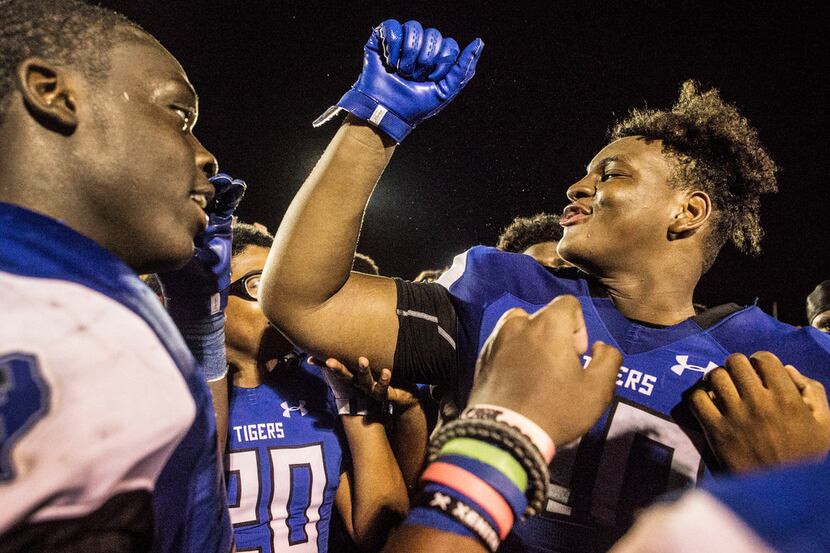 Trinity Christian's Marquette Seaton (7) talks to his teammates after a high school football...