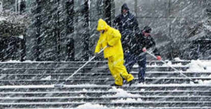  For some, the wintry conditions were more about work than play. Workers at the Capital One...
