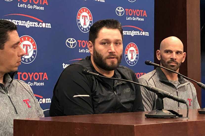 Newly signed Texas Rangers pitcher, Lance Lynn, center, responds to reporters questions as...