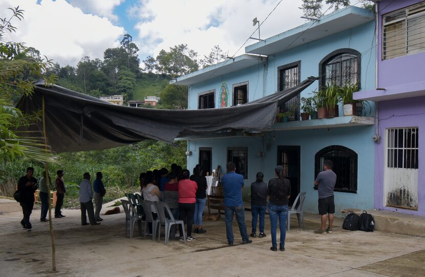 Un toldo protege del sol a vecinos, familiares y amigos que ofrecen consuelo a las familias...