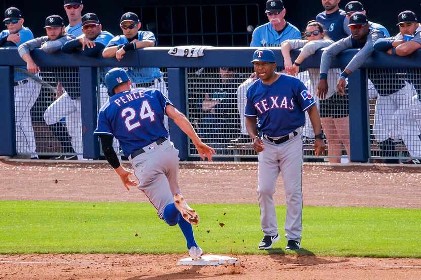 Texas Rangers third base coach Tony Beasley sends Hunter Pence home to score on a double by...