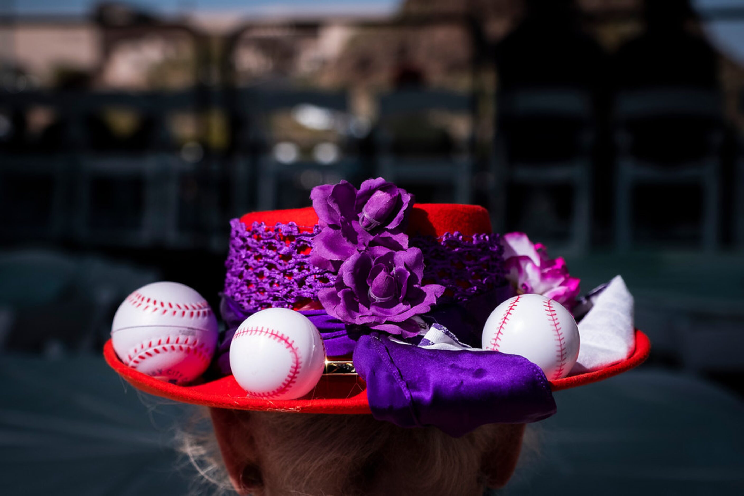 A fan wears a baseball themed hat during a spring training baseball game between the Texas...