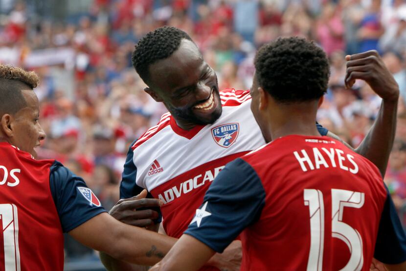 FC Dallas midfielder Roland Lamah (20), center, sports a Texas-sized smile as he celebrates...