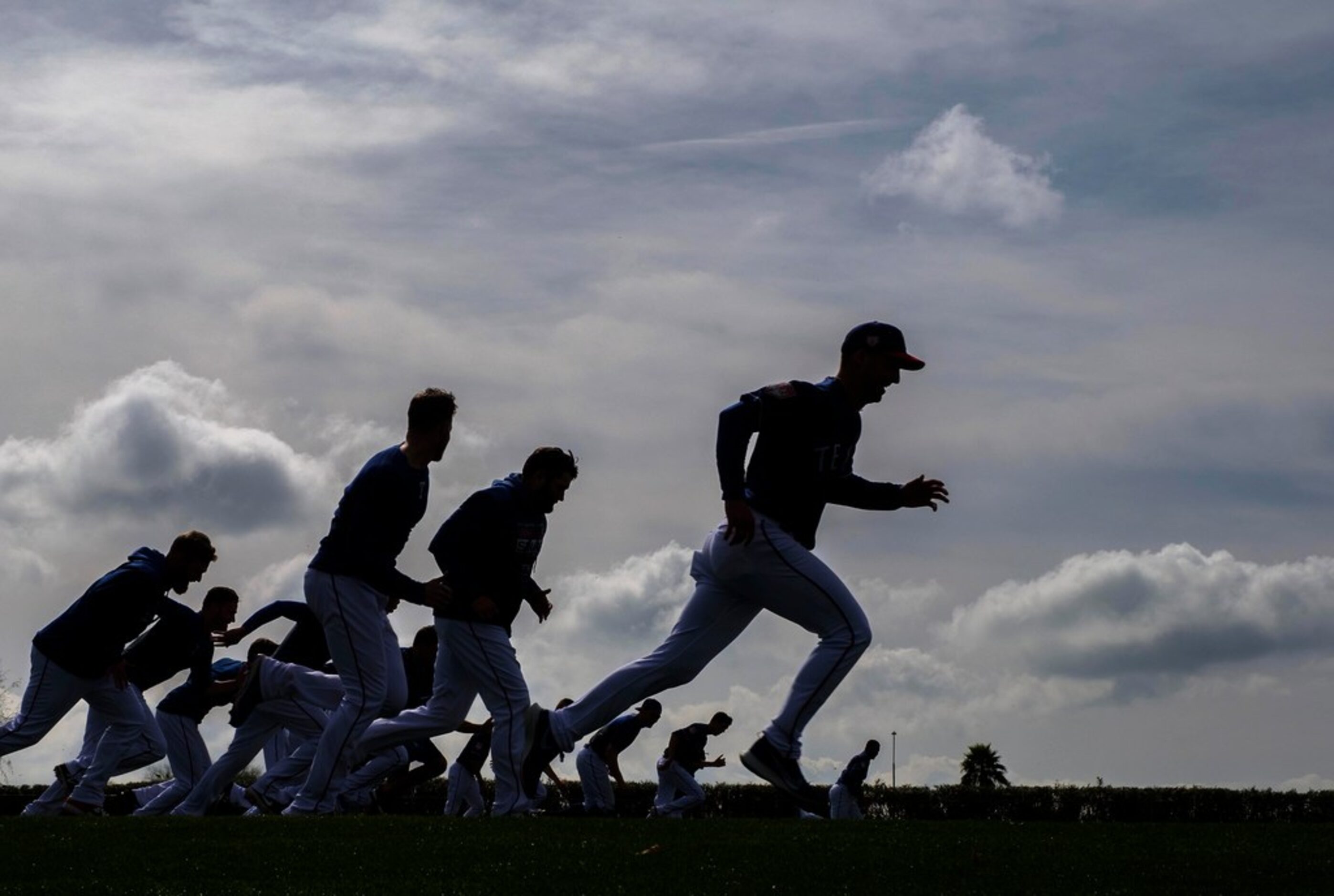 Texas Rangers pitchers run on a conditioning field during a spring training workout at the...