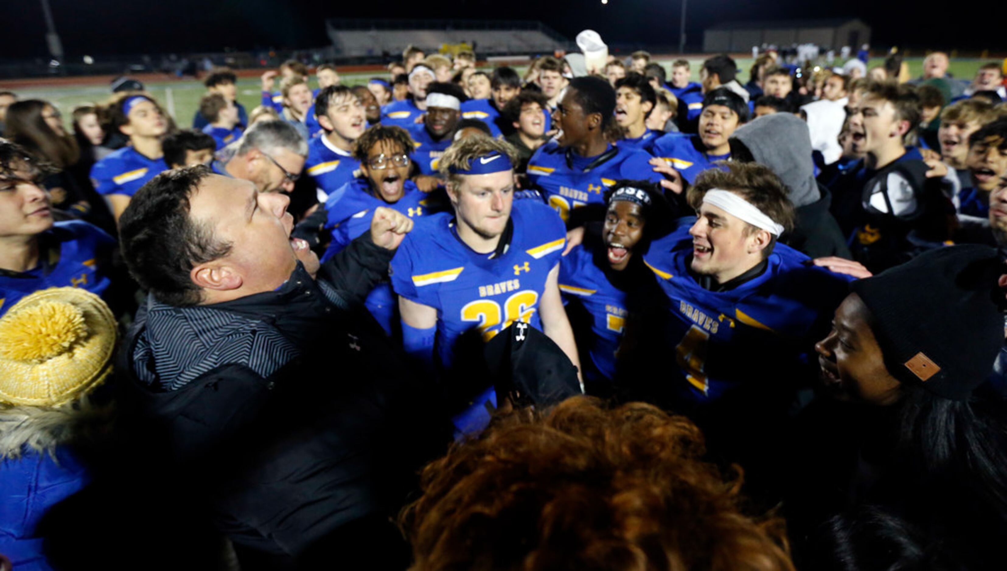 Community High head coach Jeremy Turner (left) exhaults after leading a postgame prayer with...