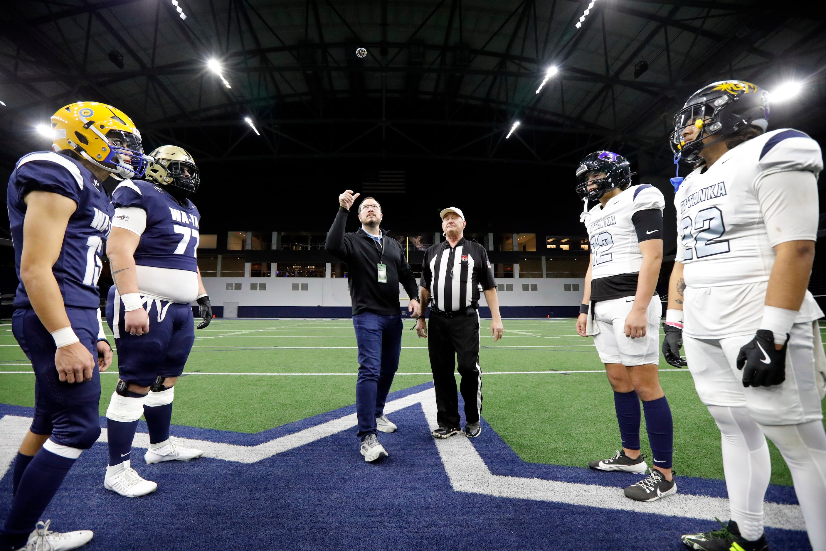 Cherokee Nation Deputy Principal Chief Bryan Warner (center) tosses the ceremonial coin as...