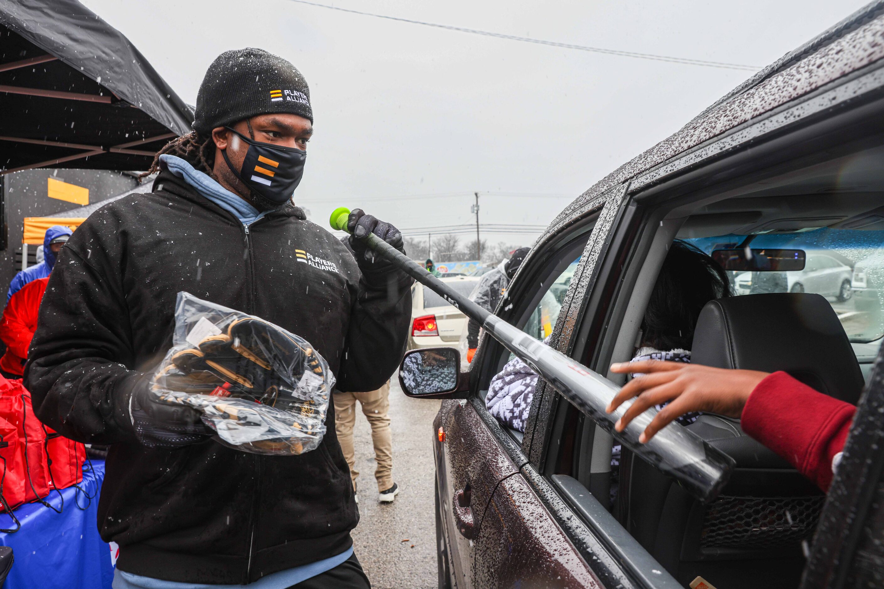 First baseman for the Washington Nationals Josh Bell, gives baseball equipment to a kid as...