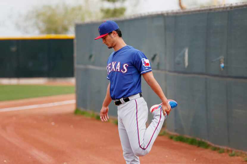  Texas Rangers pitcher Yu Darvish stretches while being the first one of the field before...