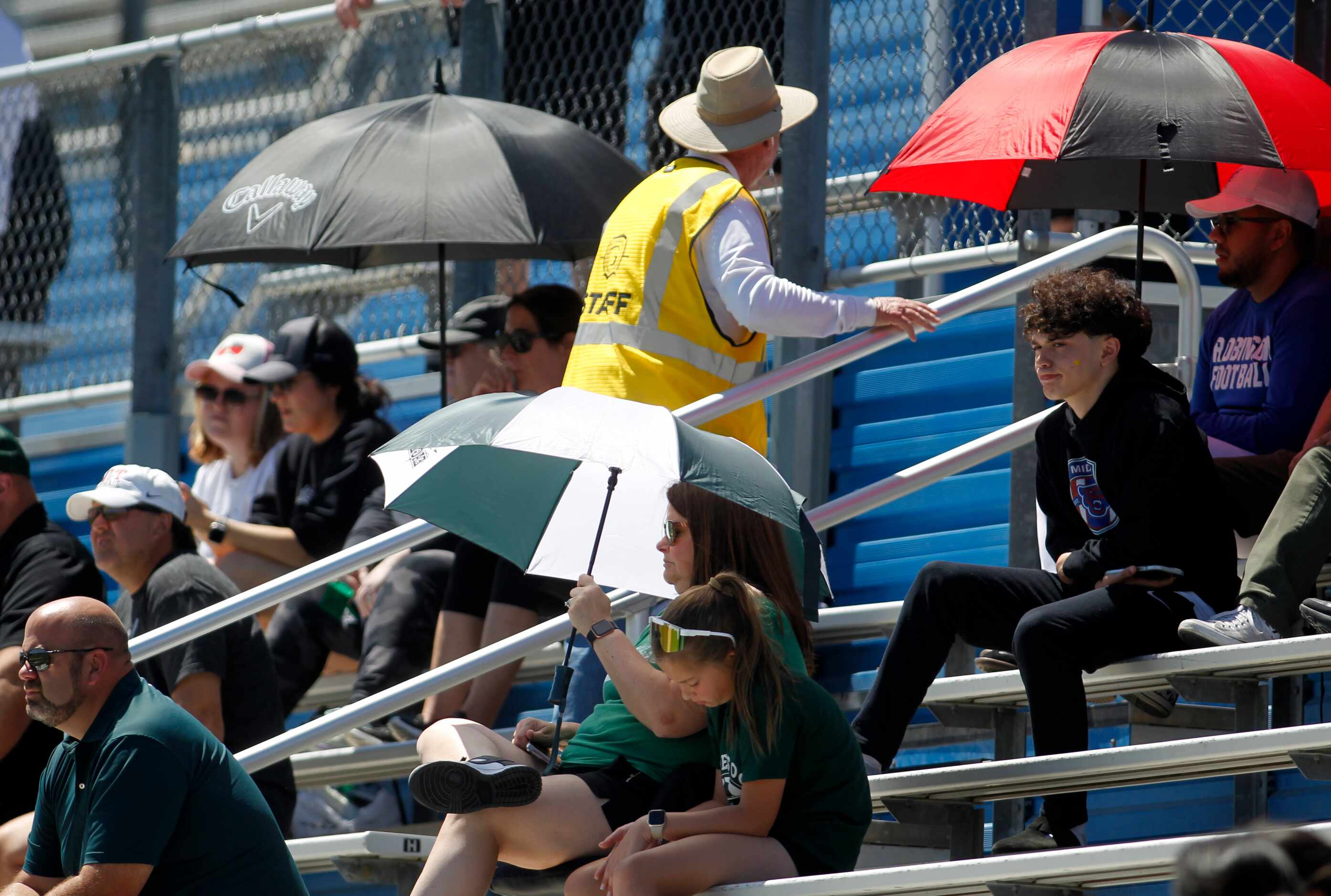  Prosper fans seek relief from the sun with umbrellas during first half action against Katy...
