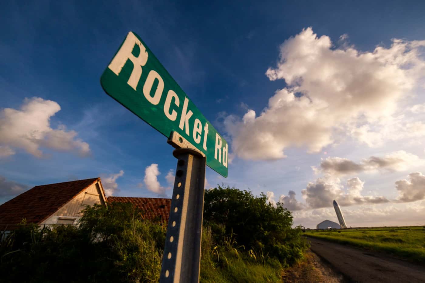 The sign for Rocket Road near is seen with a prototype of the SpaceX Starship spacecraft...