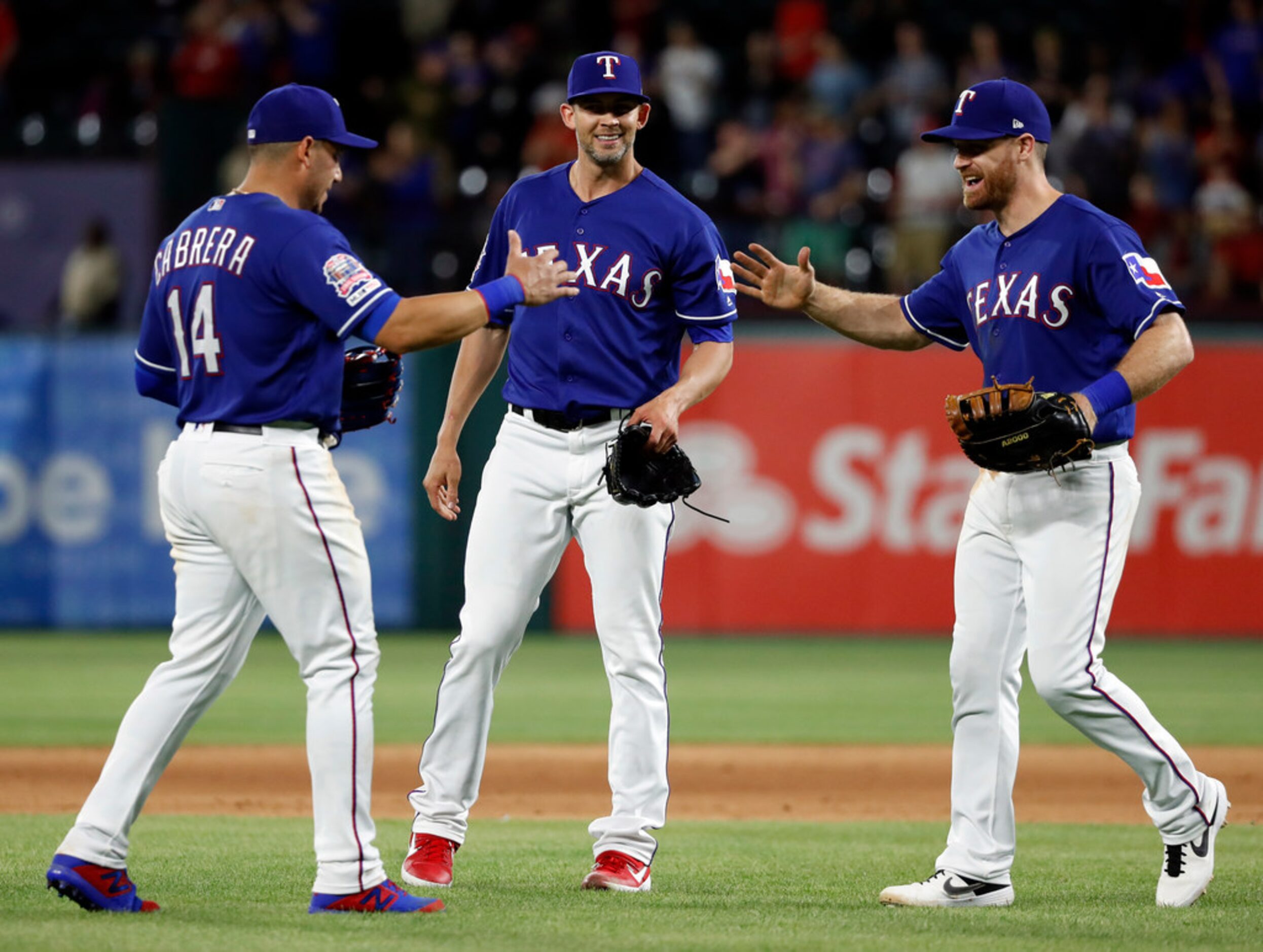 Texas Rangers' Asdrubal Cabrera (14), starting pitcher Mike Minor, center, and Logan...