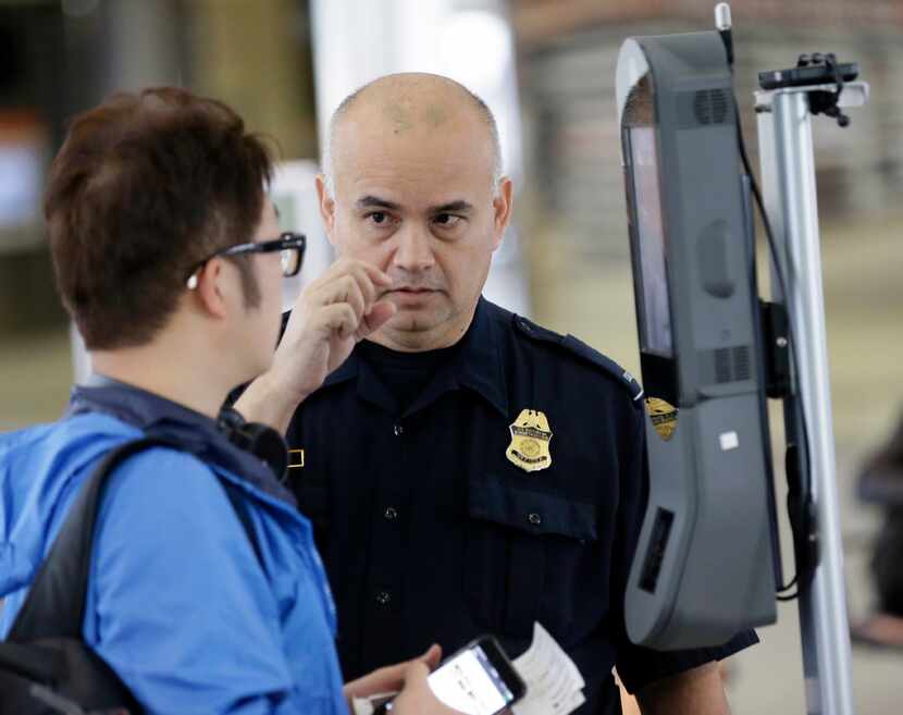 U.S. Customs and Border Protection officer Sanan Jackson helps a passenger navigate one of...