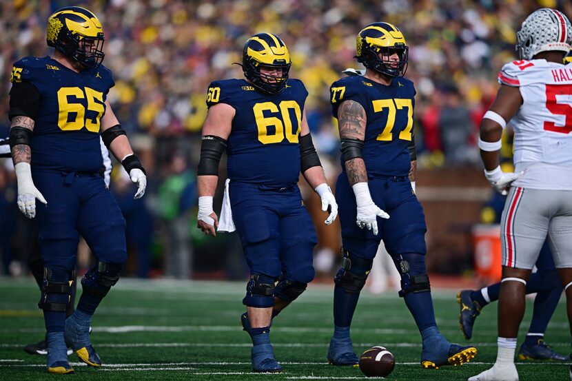 Michigan offensive linemen Zak Zinter (65), Drake Nugent (60) and Trevor Keegan (77) line up...