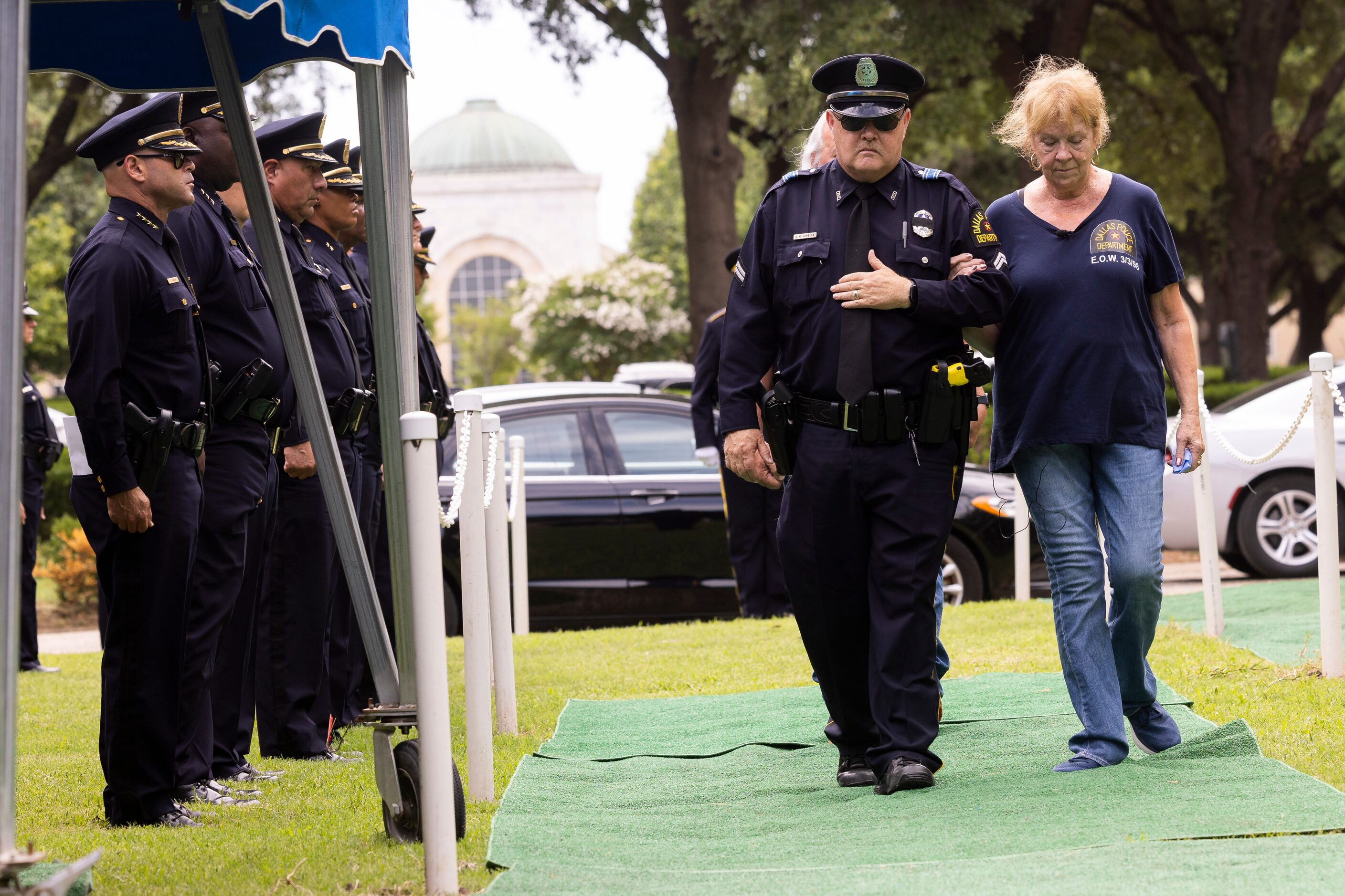 (From left) Dallas Police Chief Eddie Garcia stands at attention as Family Service Officer...