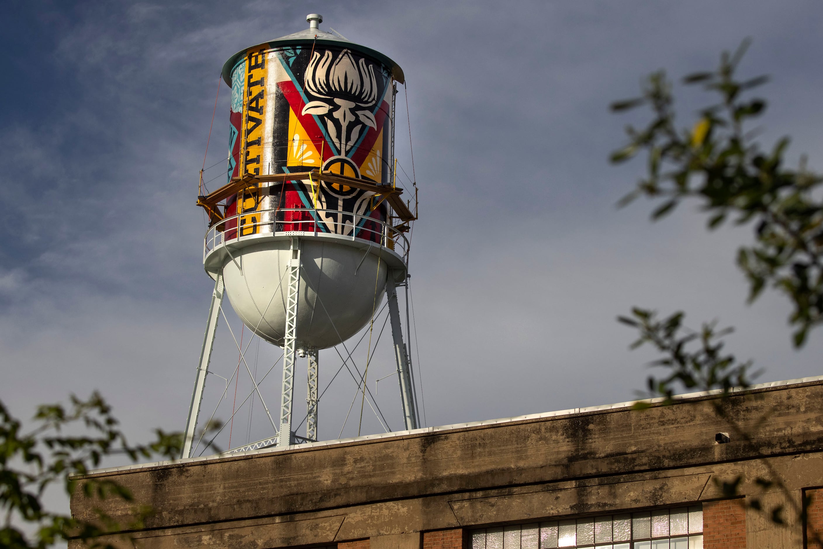 A new mural by Shepard Fairey appears on the side of a water tower by the Continental Gin...