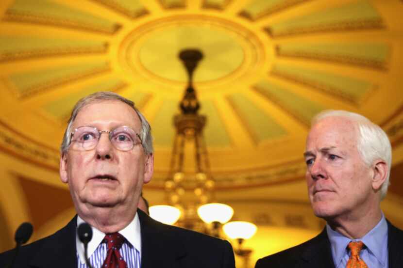 Senate Minority Leader Mitch McConnell, with Texas Sen. John Cornyn, called a group closely...