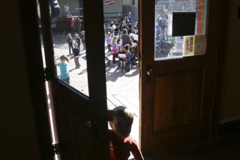 A young boy peeks inside Citizen's Bank during Lone Star History Day at Dallas Heritage...