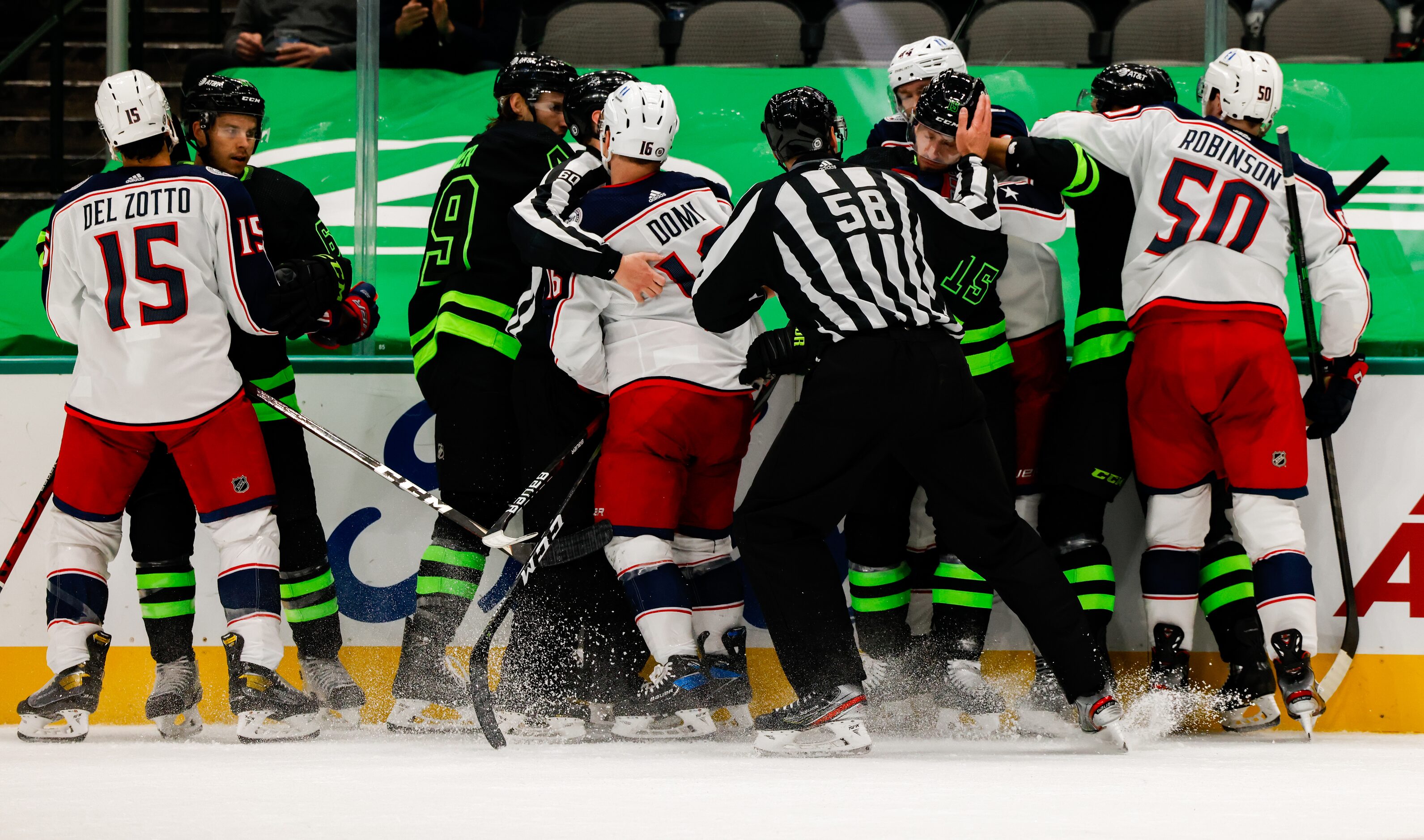 Linesman Ryan Gibbons (58) stops a fight between Dallas Stars and Columbus Blue Jackets...