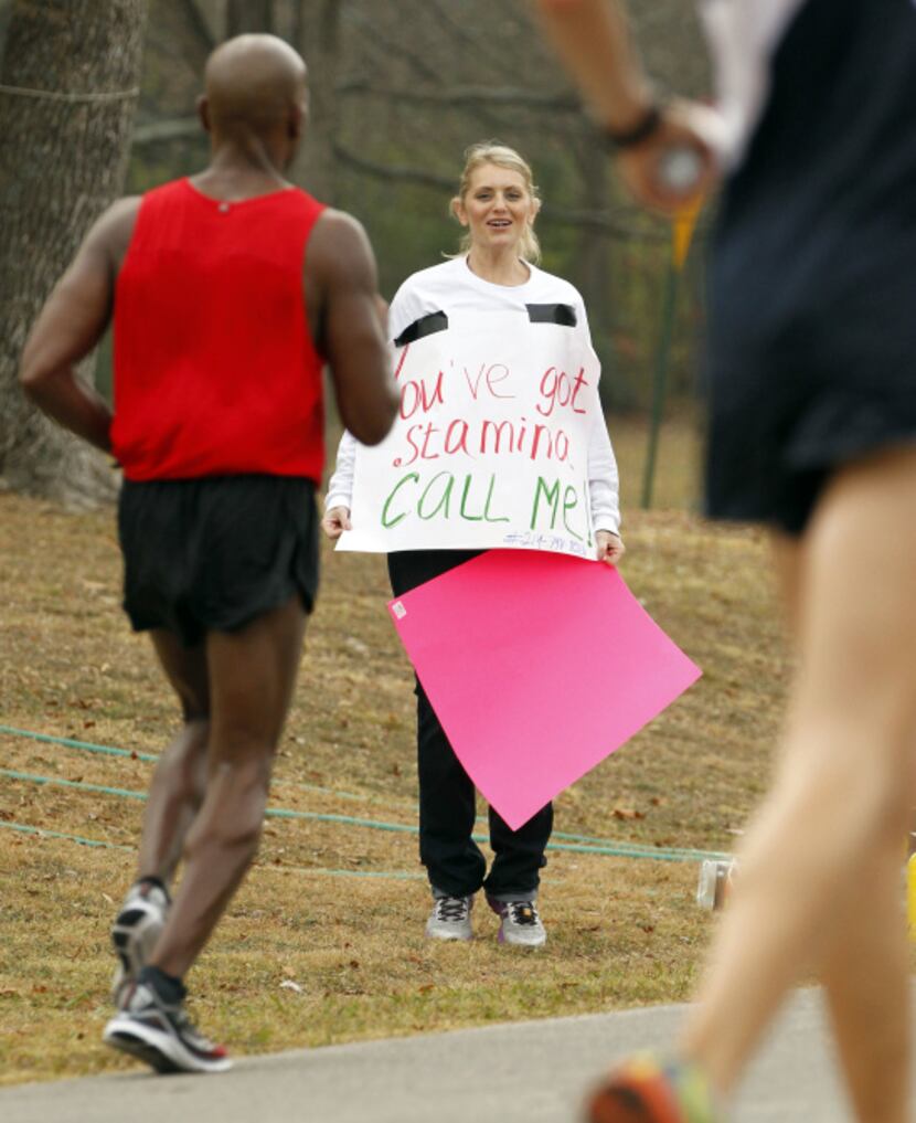 Tatyana King of Plano cheers runners on as they make their way through White Rock Lake...