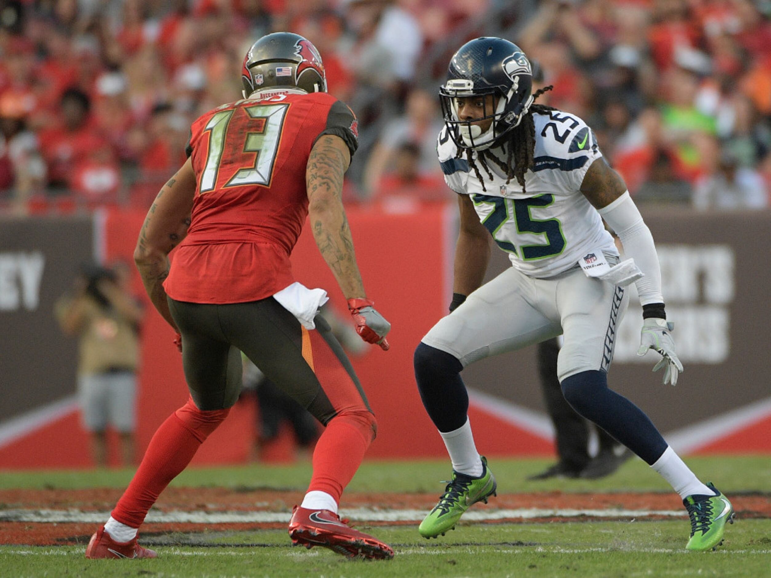 Seattle Seahawks cornerback Richard Sherman, left, begins to take