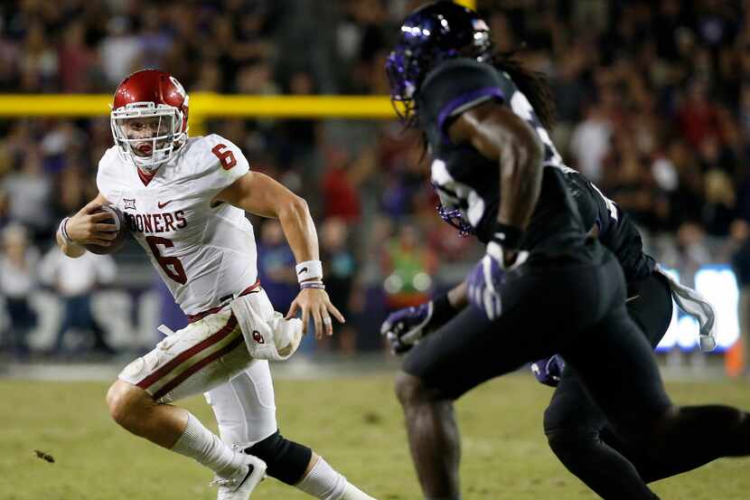 Oklahoma quarterback Baker Mayfield (6) is chased by TCU safety Denzel Johnson (30) and...