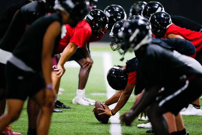 Euless Trinity’s varsity football team runs drills during a practice at Euless Trinity High...