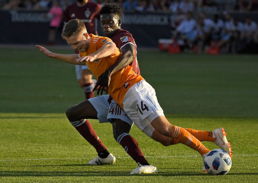 Houston Dynamo defender Adam Lundqvist, front, and Colorado Rapids forward Dominique Badji...