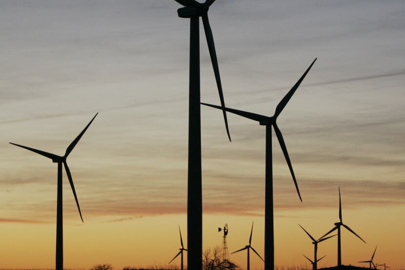 FILE - In this March 11, 2009 file photo, a wind mill, rear center, supplies water to a...