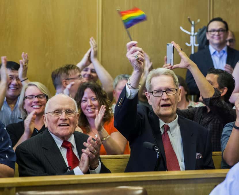 Jack Evans, right, waves a flag as George Harris cheers after an announcement that marriage...