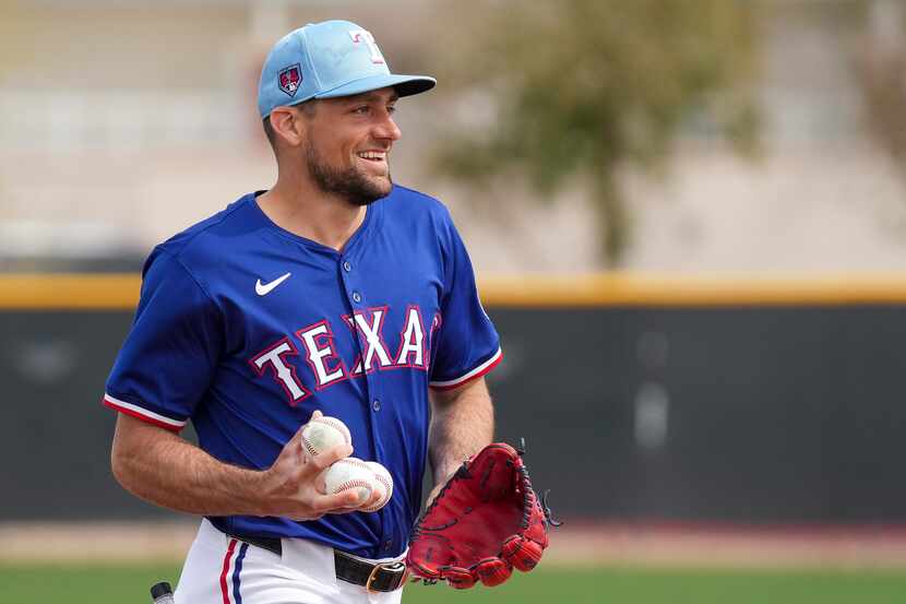Texas Rangers pitcher Nathan Eovaldi laughs after fielding three consecutive balls in a...