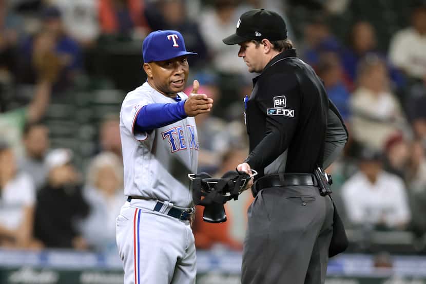 Texas Rangers interim manager Tony Beasley argues an out call with home plate umpire Adam...