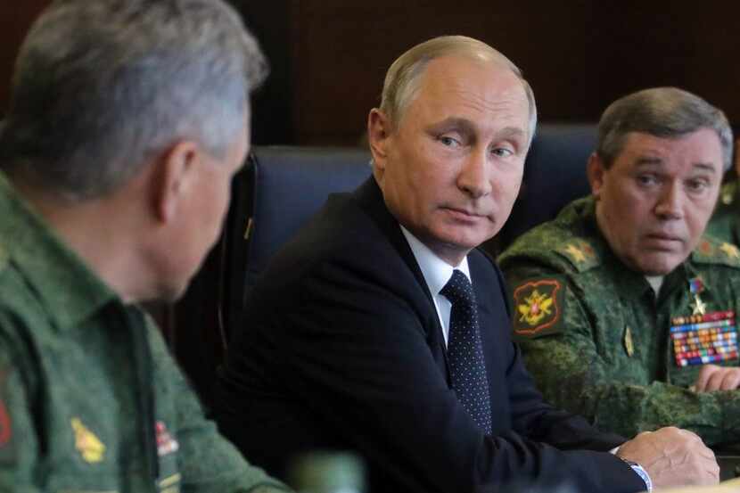 Russian President Vladimir Putin (C), accompanied by Defence Minister Sergei Shoigu (L) and...