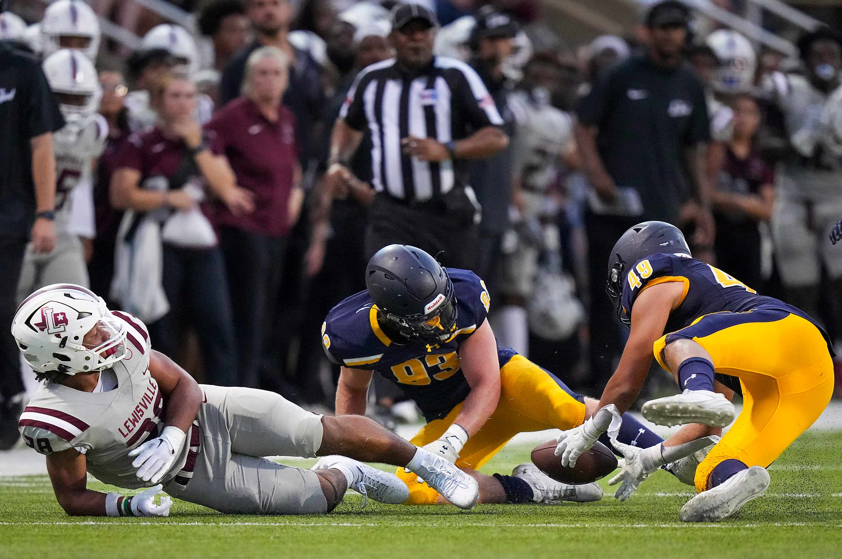Highland Park linebacker Jack Morse (49) recovers a Lewisville fumble in front of defensive...