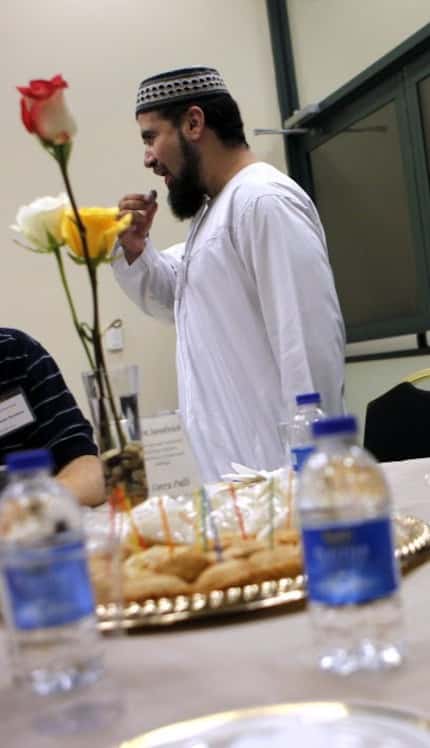 Imam Zia Sheikh breaks a dawn-to-dusk fast during a Ramadan dinner at the Islamic Center of...
