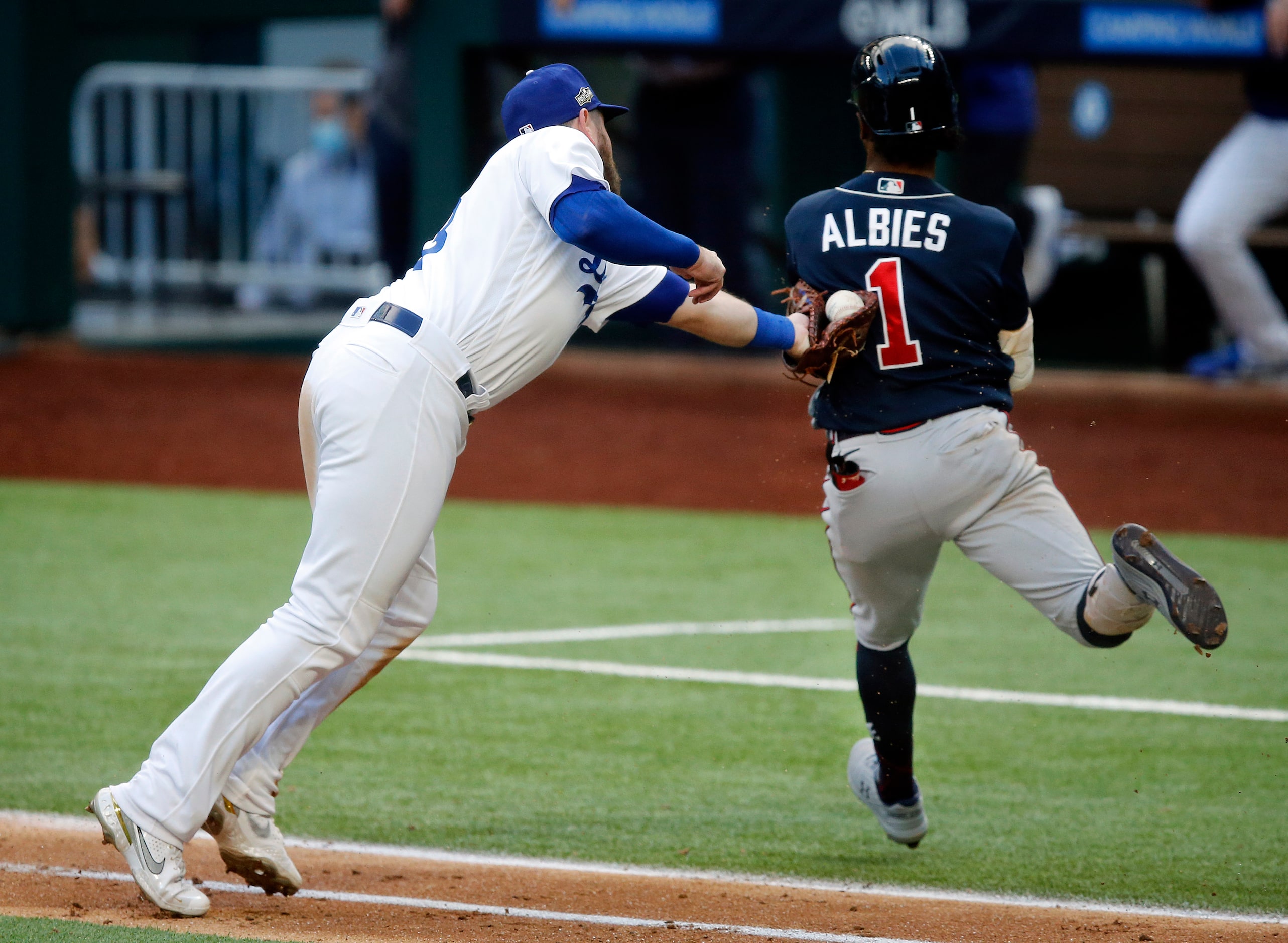 Los Angeles Dodgers first baseman Max Muncy (13) attempts to tag Atlanta Braves batter Ozzie...