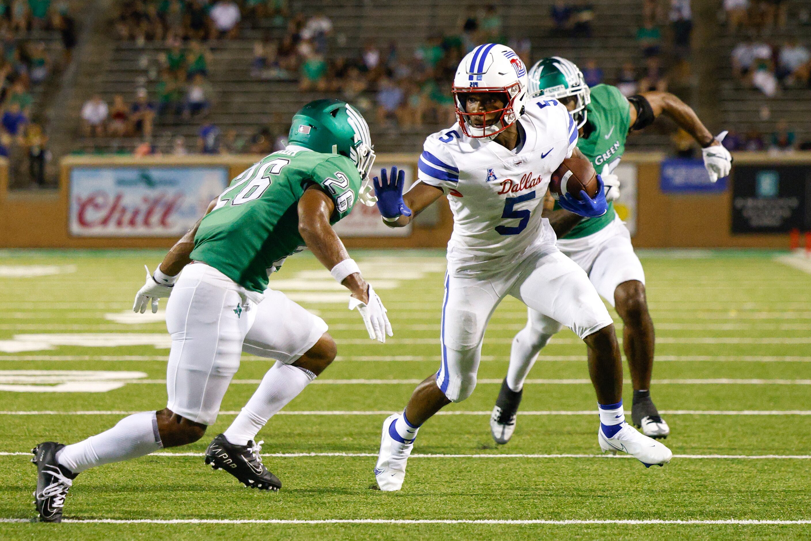 SMU wide receiver Moochie Dixon (5) stiff-arms UNT defensive back Ridge Texada (26) as he...