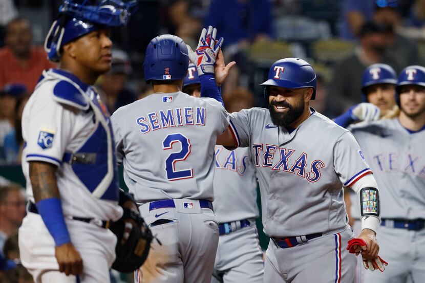 Texas Rangers' Marcus Semien (2) is congratulated by Sandy Leon, right, after hitting a...