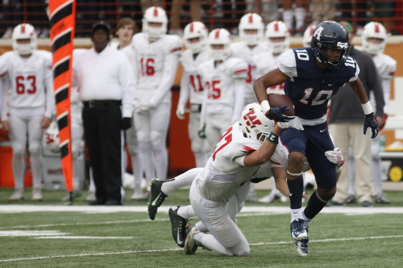Allen's Theo Wease, 10, tries to escape The Woodland's Troy Kuchen's tackle during the UIL...