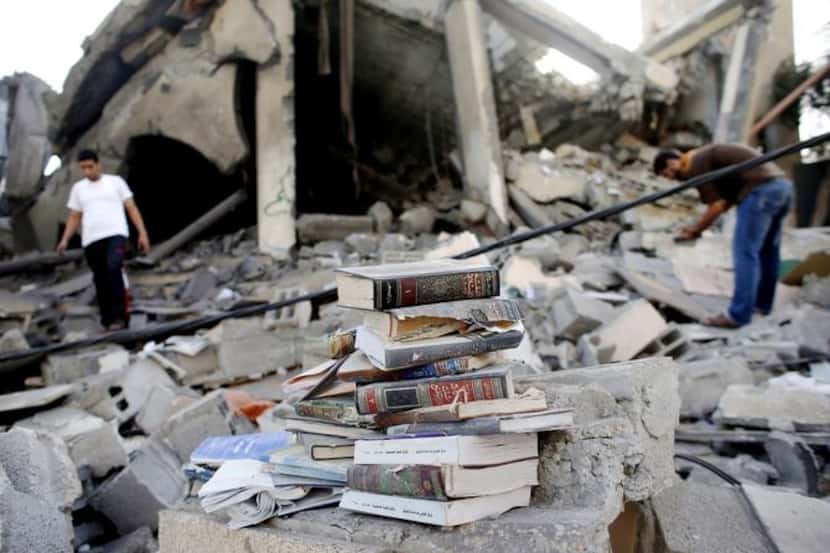 
Palestinians collected copies of the Quran from a mosque after an Israeli airstrike in a...