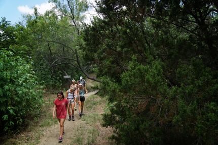 Students from Richardson's J.J. Pearce High School hike at Cedar Hill State Park during a...