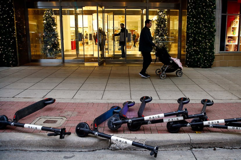 Bird rental scooters lie on the ground outside the Neiman Marcus store in downtown Dallas